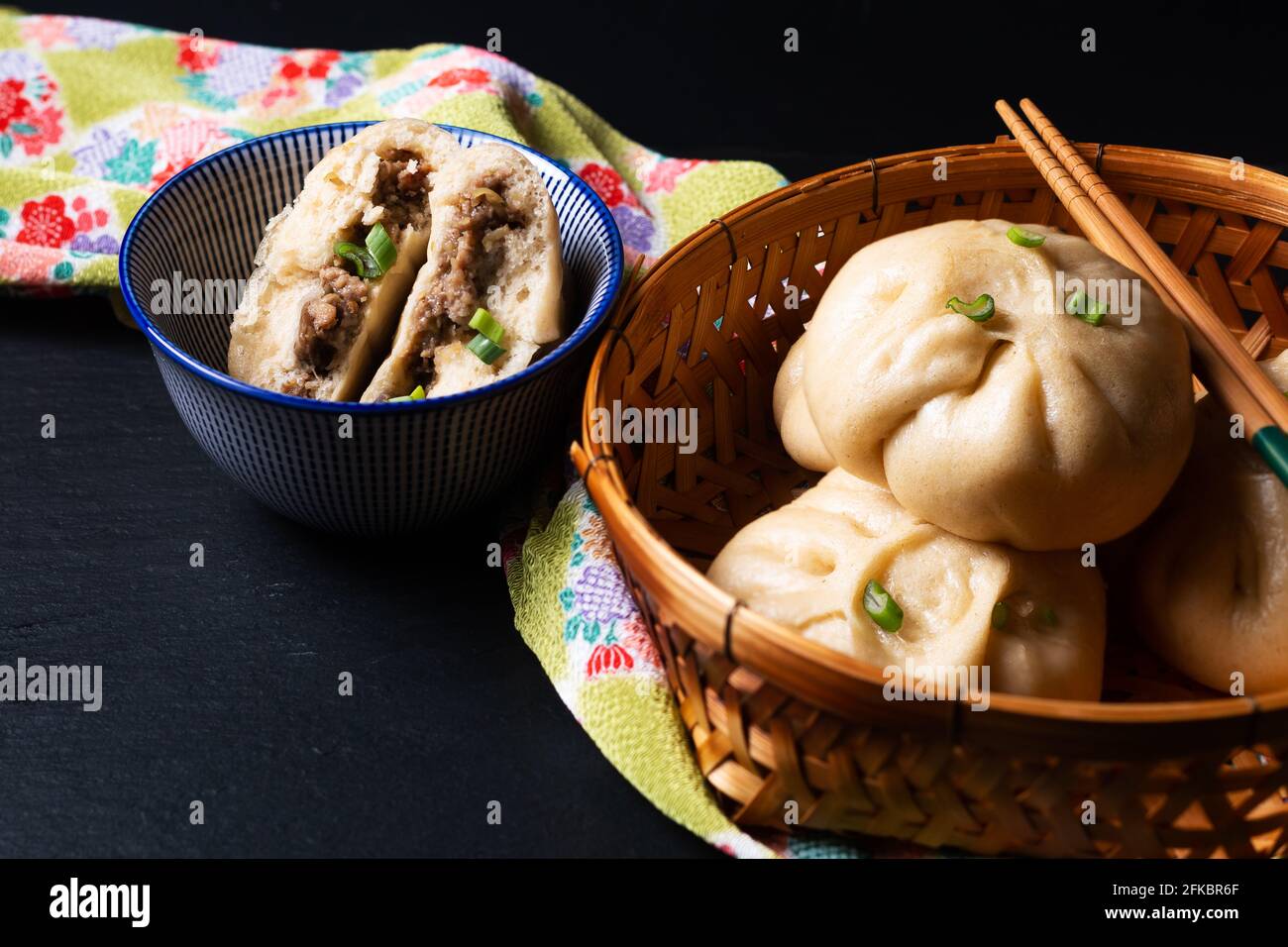 Concetto di cibo punto fuoco fatto in casa dim sum Baozi biologico, o bao maiale cinese al vapore Buns su sfondo nero con spazio di copia Foto Stock