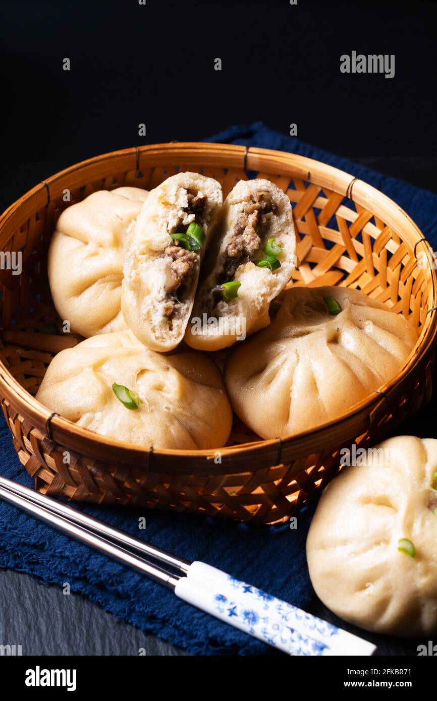 Concetto di cibo punto fuoco fatto in casa dim sum Baozi biologico, o bao maiale cinese al vapore Buns su sfondo nero con spazio di copia Foto Stock