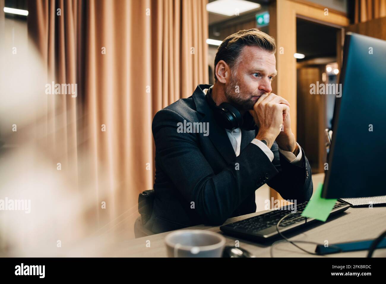 Uomo d'affari preoccupato che lavora sul computer in ufficio Foto Stock