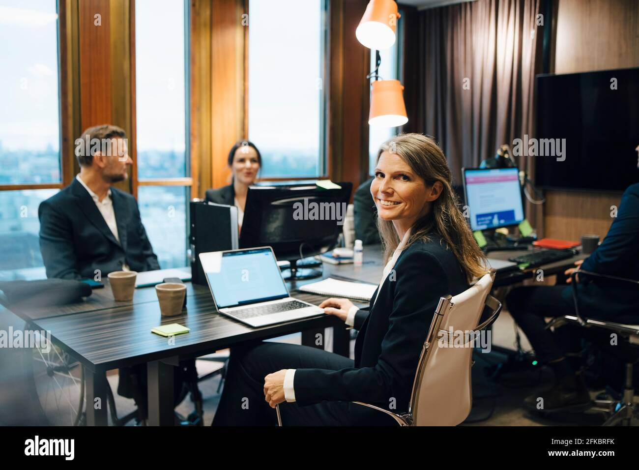 Ritratto di una donna avvocato seduta con i colleghi durante l'incontro ufficio Foto Stock