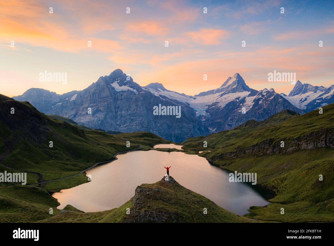 Simpaticissimo escursionista che ammirava Wetterhorn, Schreckhorn e Finsteraarhorn da Bachalpsee all'alba, Oberland Bernese, Svizzera, Europa Foto Stock