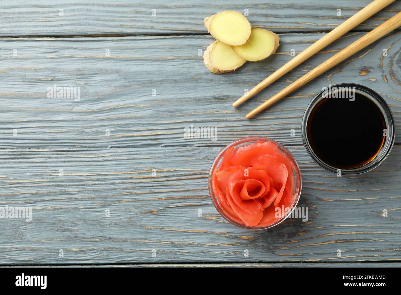Ciotola di zenzero sottaceto, salsa di soia e trissini su un tavolo di legno Foto Stock