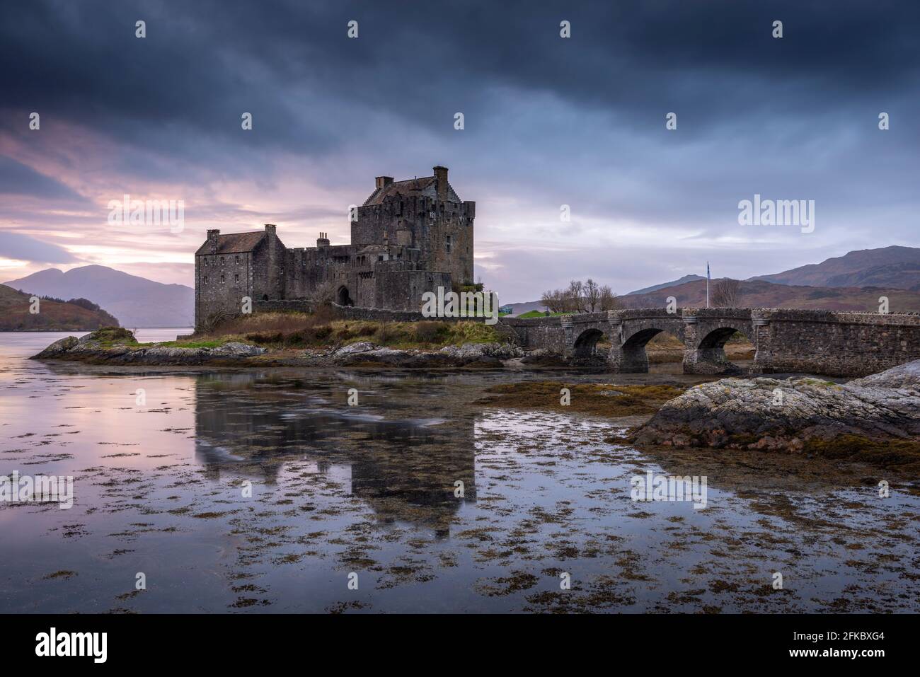 Tramonto dietro il Castello di Eilean Donan sul Loch Duich nelle Highlands scozzesi, Scozia, Regno Unito, Europa Foto Stock