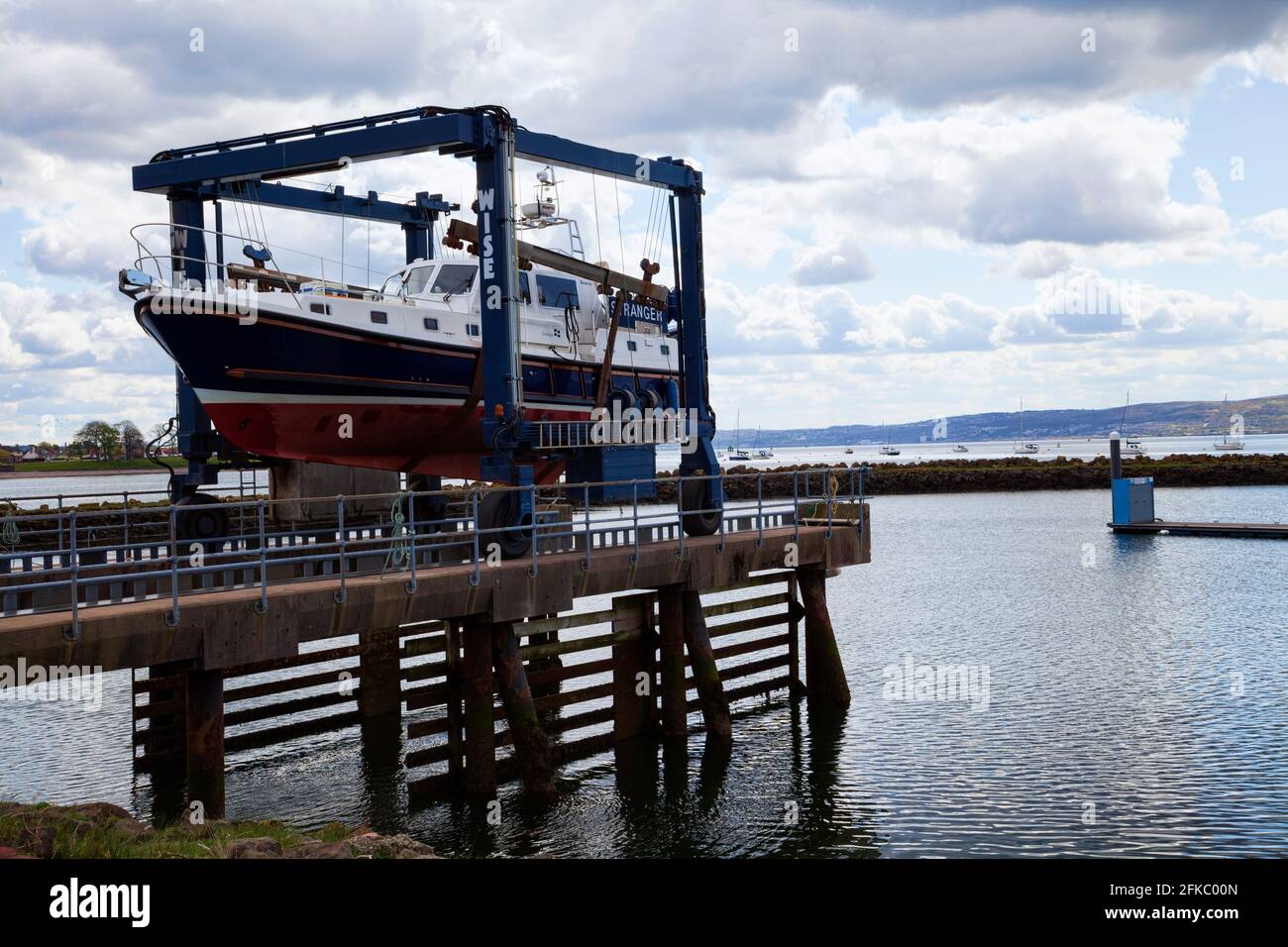 Motoscafo sulla barca di sollevamento che viene messo in acqua all'inizio della stagione, Rhu, Scozia Foto Stock