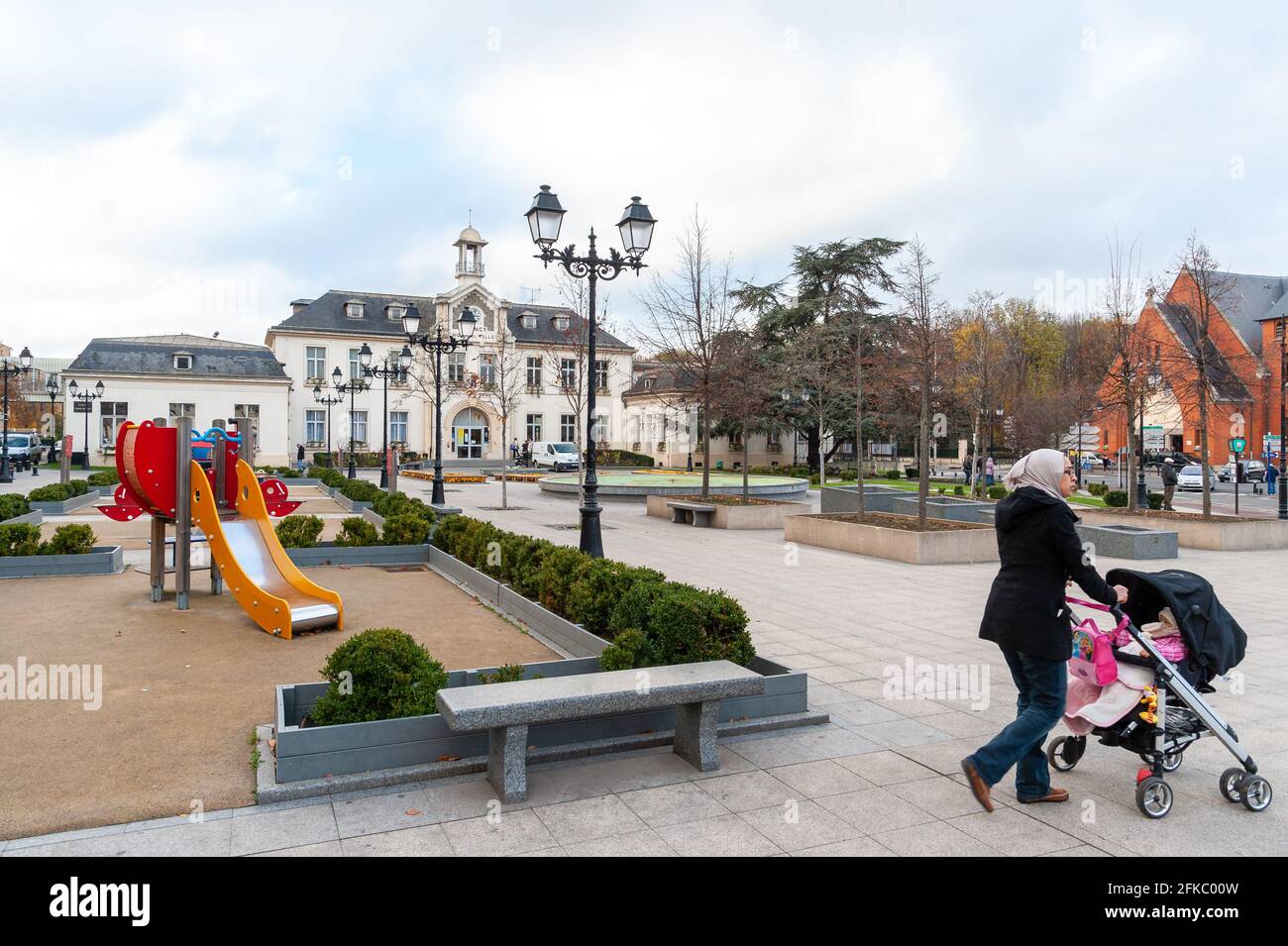 Donna musulmana nel centro del sobborgo parigino di Drancy passando l'Hotel de Ville Foto Stock