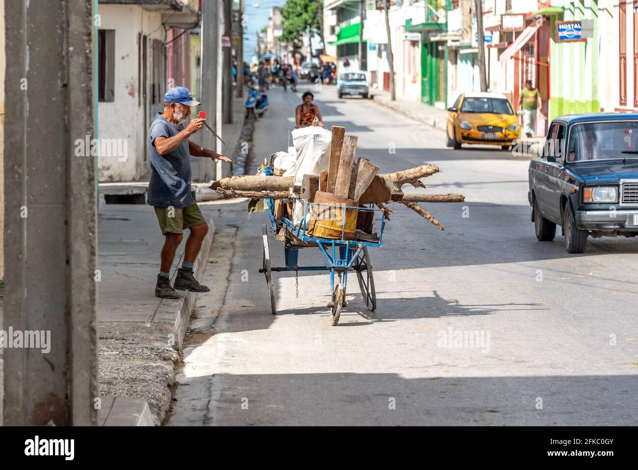 Uomo anziano che raccoglie i pezzi scartati di legno nella città. Santa Clara, Cuba, 2016 Foto Stock