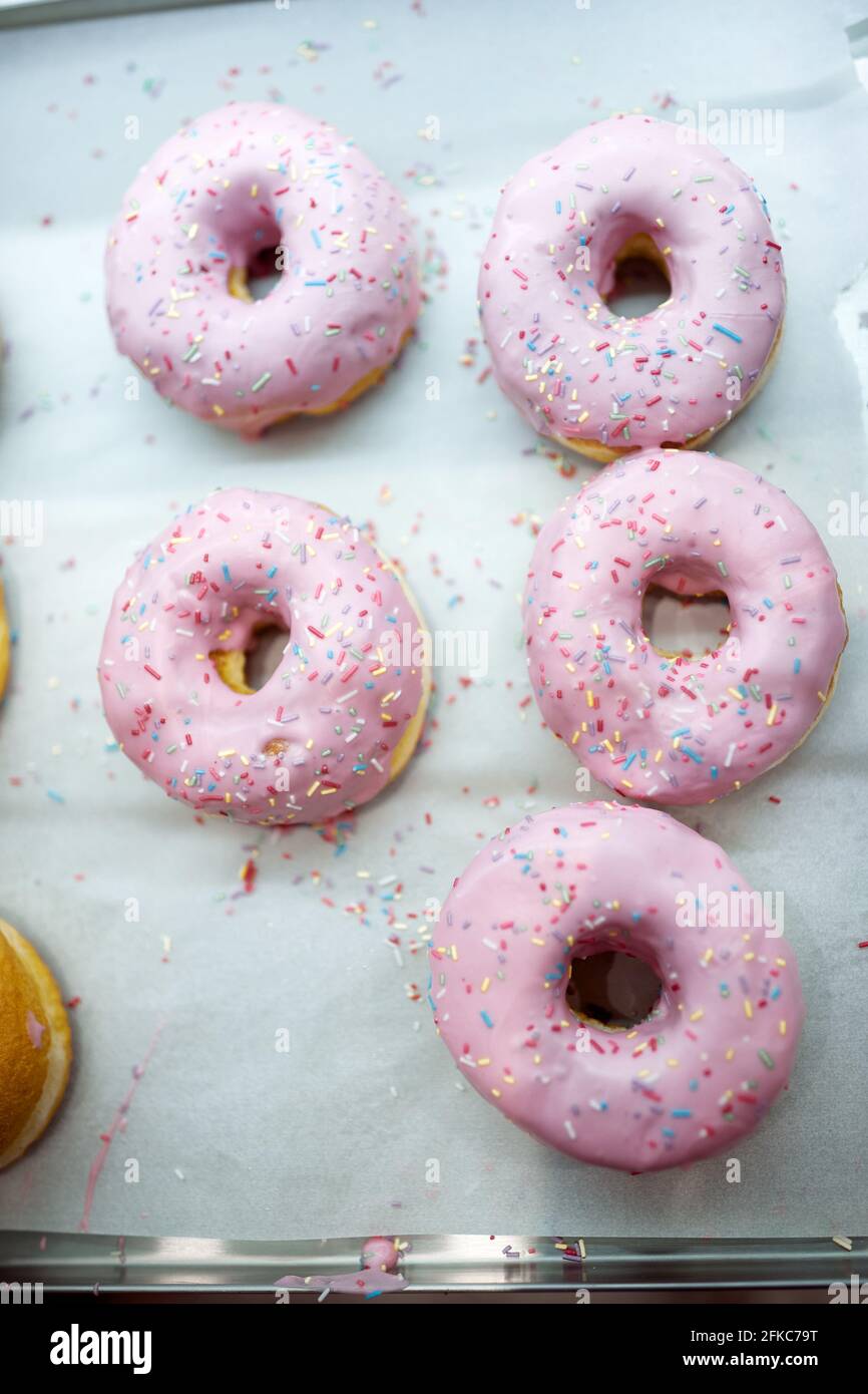 Dolci e deliziose ciambelle dall'aspetto irresistibile pronte per il trasporto alla pasticceria. Pasticceria, dessert, dolce Foto Stock