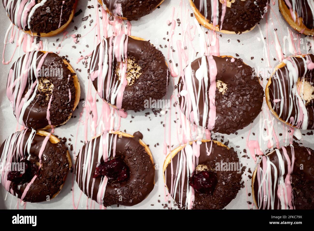 Closeup di deliziose ciambelle dall'aspetto irresistibile pronte per il trasporto alla pasticceria. Pasticceria, dessert, dolce Foto Stock