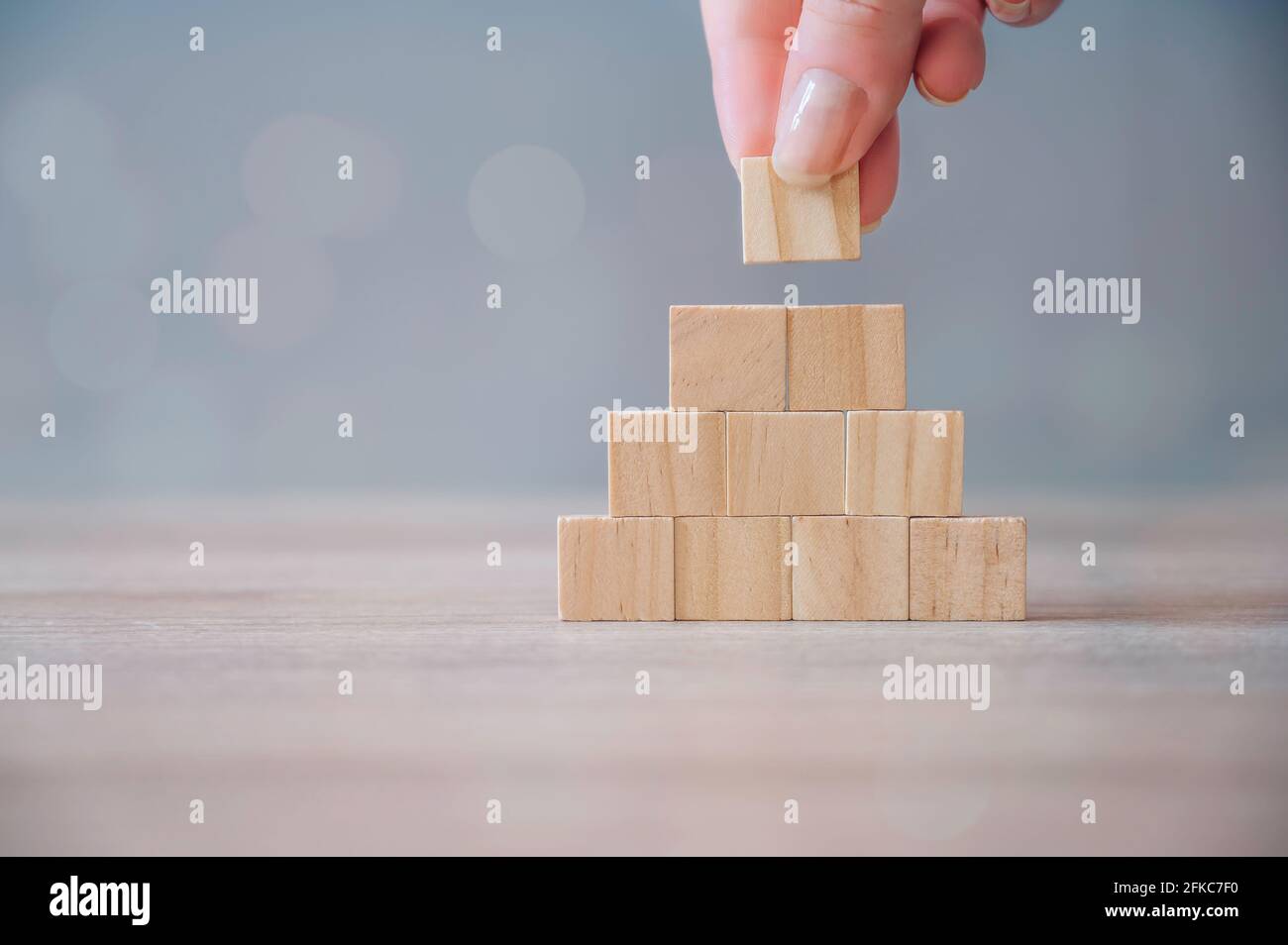 Disposizione manuale dei blocchi di legno. Crescita aziendale, successo, concetto di processo. Blocchi di legno sbozzati su sfondo di legno Foto Stock