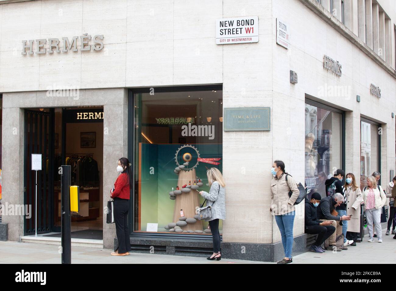 Londra, Regno Unito, 30 aprile 2021: Anche il venerdì mattina le boutique di lusso di Bond Street attirano clienti fedeli disposti a fare la coda per un'esperienza di shopping socialmente distanziata e tornare a casa con alcuni acquisti di marchi di stilisti. Anna Watson/Alamy Live News Foto Stock