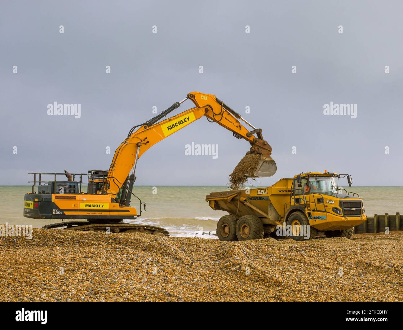 Impianto pesante che lavora sulla spiaggia di Eastbourne a East Sussex, Regno Unito. Spostamento di ghiaia da una zona temuta della spiaggia. Foto Stock