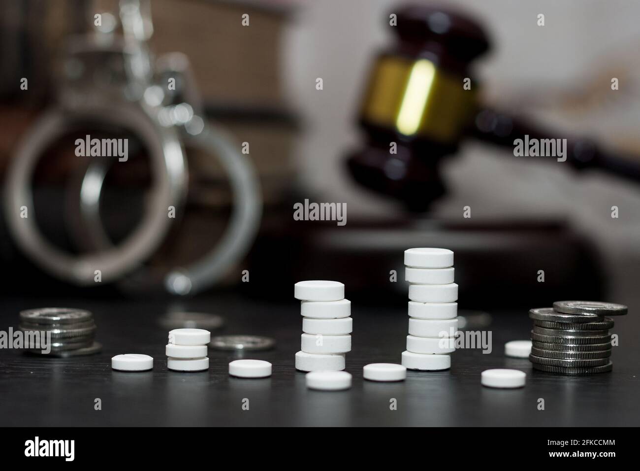 Giudice di martello con manette, farmaci sul tavolo di legno, concetto di droga Foto Stock