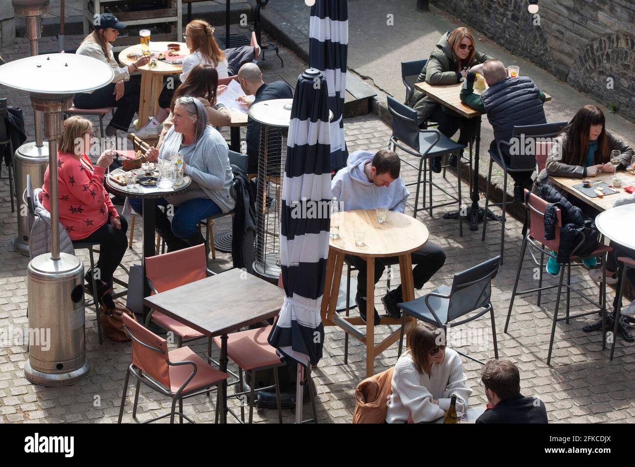 Londra, Regno Unito. 30 Apr 2021. I ristoranti del Borough Market ospitano cene e bevitori in una fredda giornata di sole. Alcuni sono aperti ai clienti che effettuano il drop-in, mentre altri richiedono la prenotazione e un controllo della temperatura. Anche se il tempo è più freddo del solito per il periodo dell'anno è rimasto asciutto abbastanza per i clienti di godere i loro pasti. Credit: Anna Watson/Alamy Live News Foto Stock