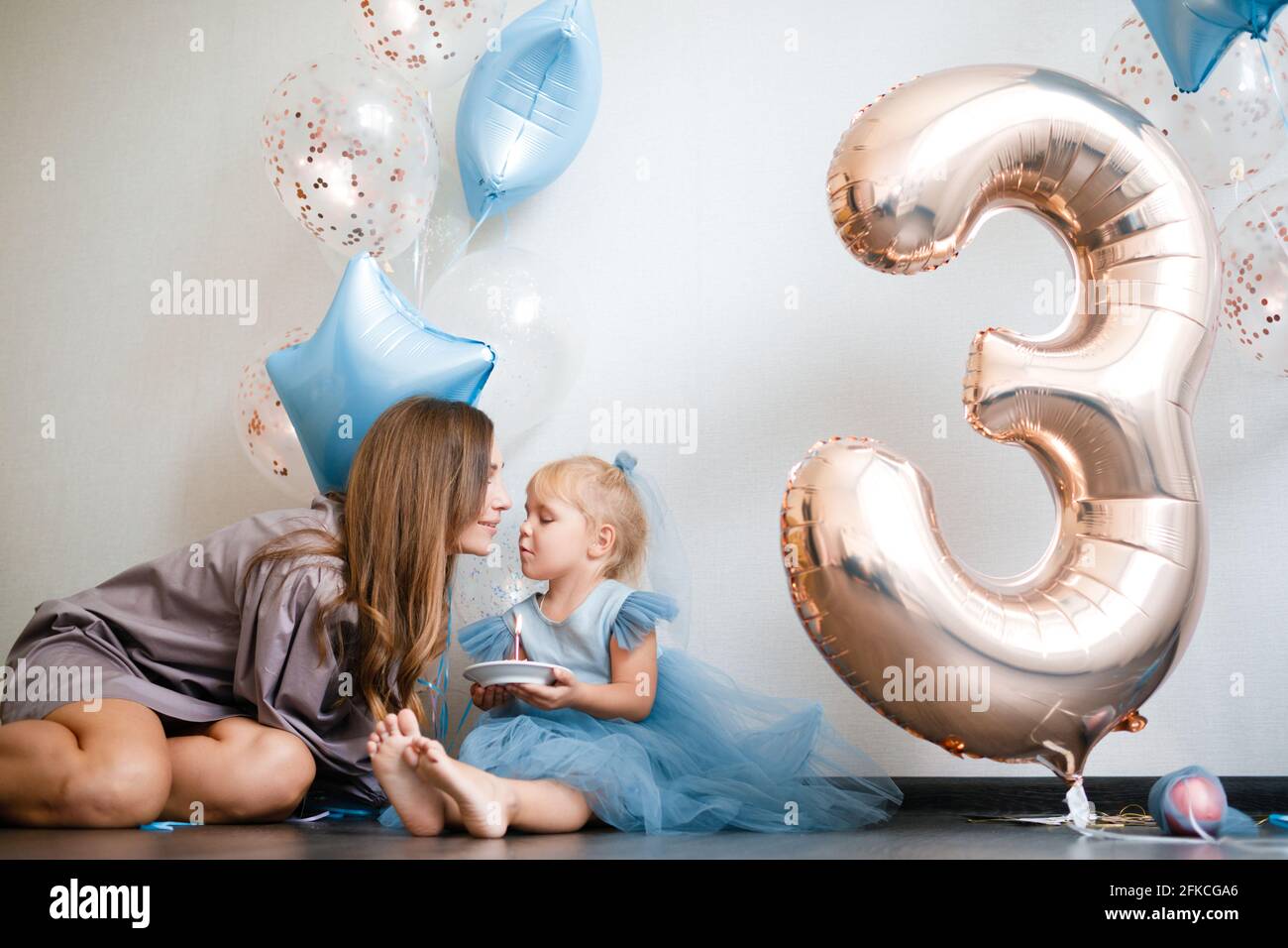 Madre e figlia festeggiano il loro compleanno in abiti di bellezza con palloncini. Foto Stock