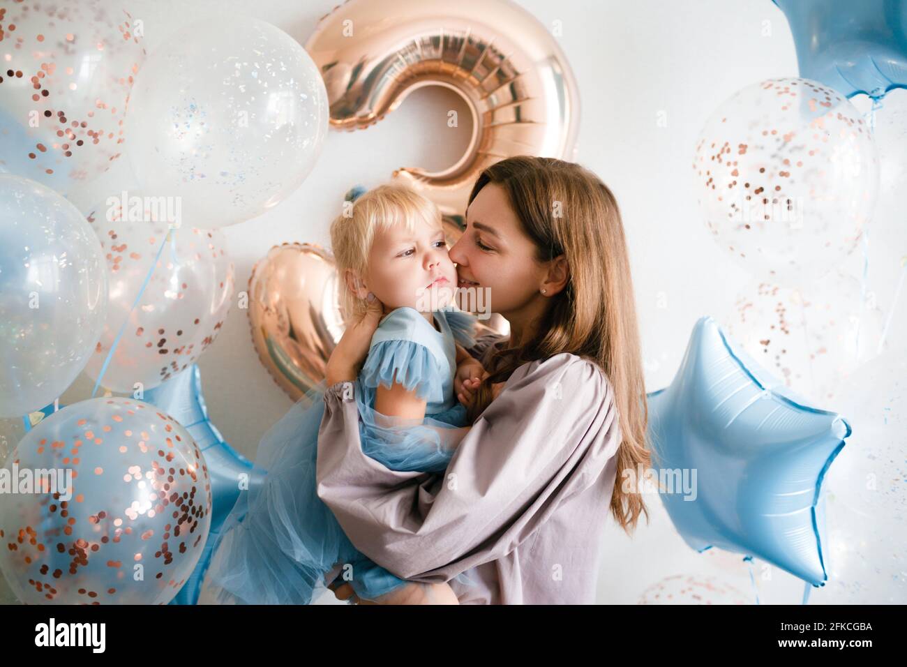 Madre e figlia festeggiano il loro compleanno in abiti di bellezza con palloncini. Foto Stock