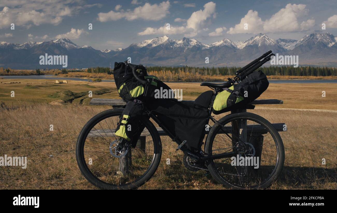 La bicicletta cicloturistica a terreno misto con bikepacking. Il viaggio in bicicletta multitraccia, strada all'aperto in montagna innevata. Foto Stock