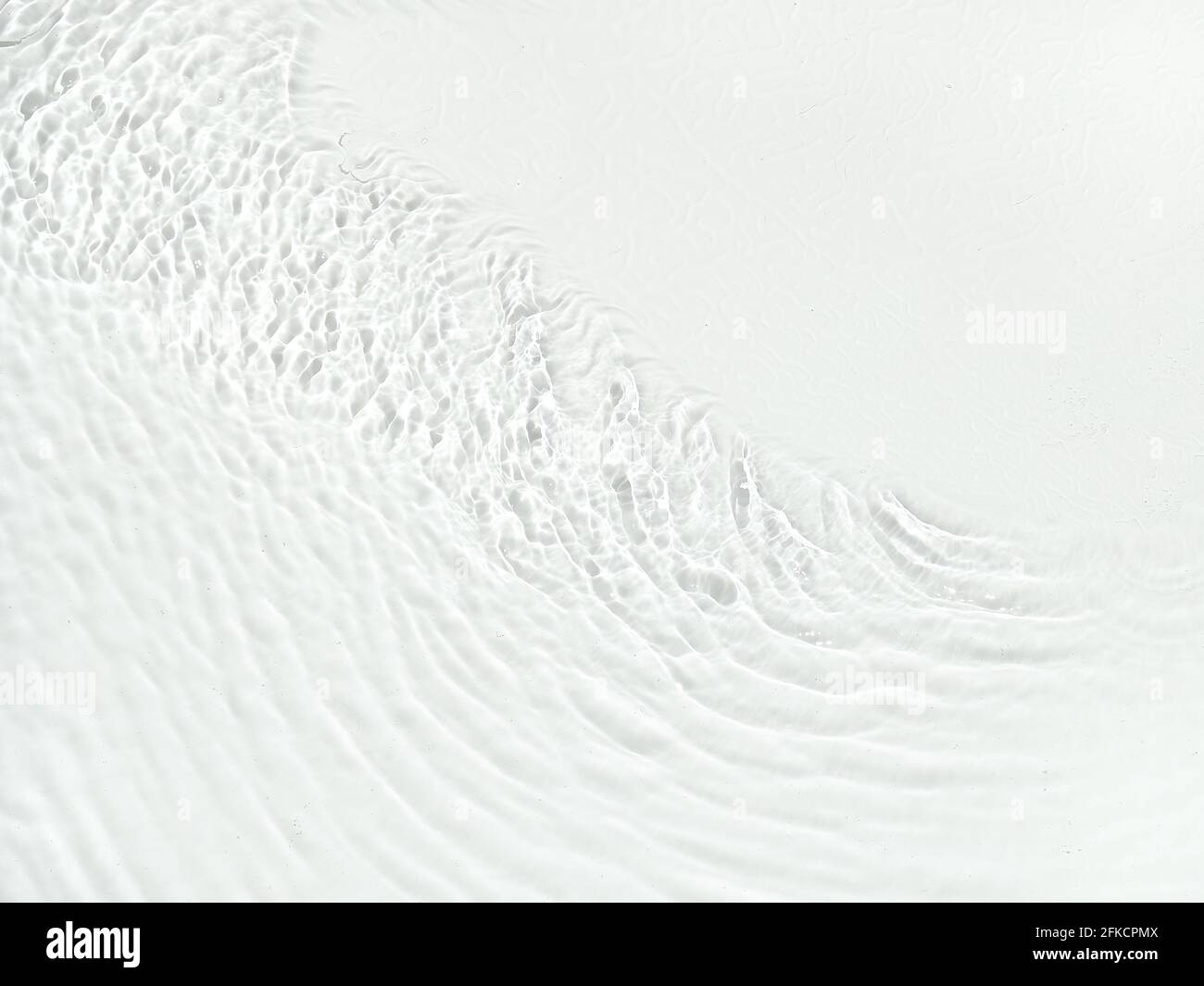 Superficie dell'acqua con onde e ondulazione. Struttura in acqua naturale trasparente bianca. Concetto di spa. Disposizione piatta, vista dall'alto, spazio per la copia, spazio per la copia Foto Stock