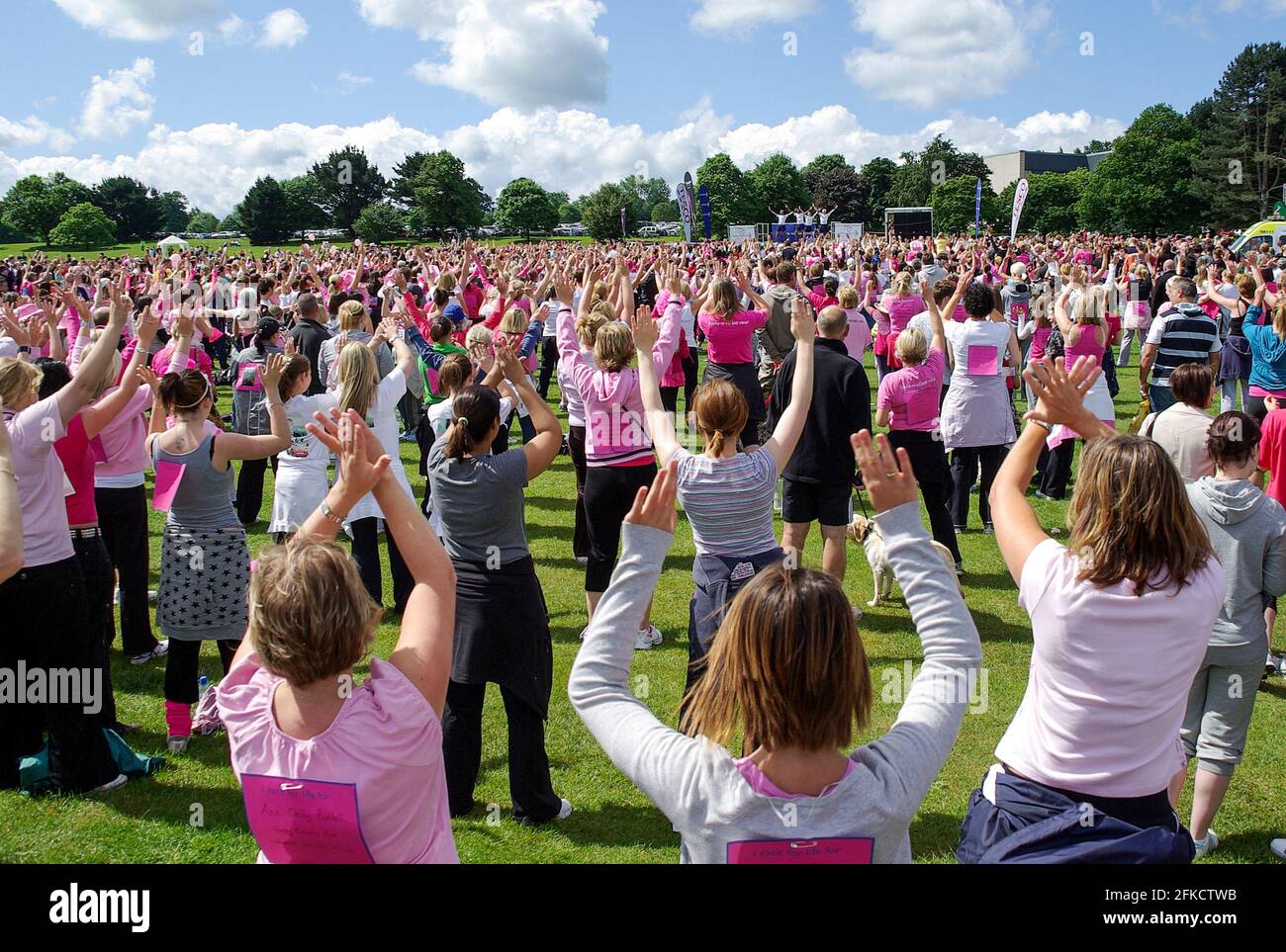 Le donne si riscaldano prima di iniziare una corsa di divertimento Cancer Research Race for Life a Moat Park, Maidstone, Kent, Regno Unito. Donne, donne che corrono per carità Foto Stock