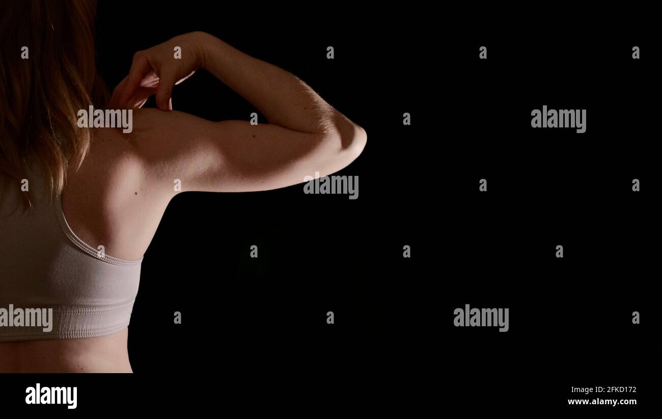 Donna torna in abbigliamento sportivo durante l'allenamento in posa su uno sfondo nero isolato senza volto. L'immagine mostra i muscoli femminili e un corpo sano e bello Foto Stock Donna torna in abbigliamento sportivo durante l'allenamento in posa su uno sfondo nero isolato senza volto. L'immagine mostra i muscoli femminili e un corpo sano e bello Foto Stock