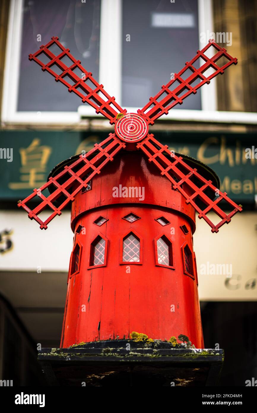 Moulin Rouge Llandudno - modello a mulino Rosso su Mostyn St Llandudno, situato all'esterno dell'ex caffetteria Moulin Rouge. Foto Stock