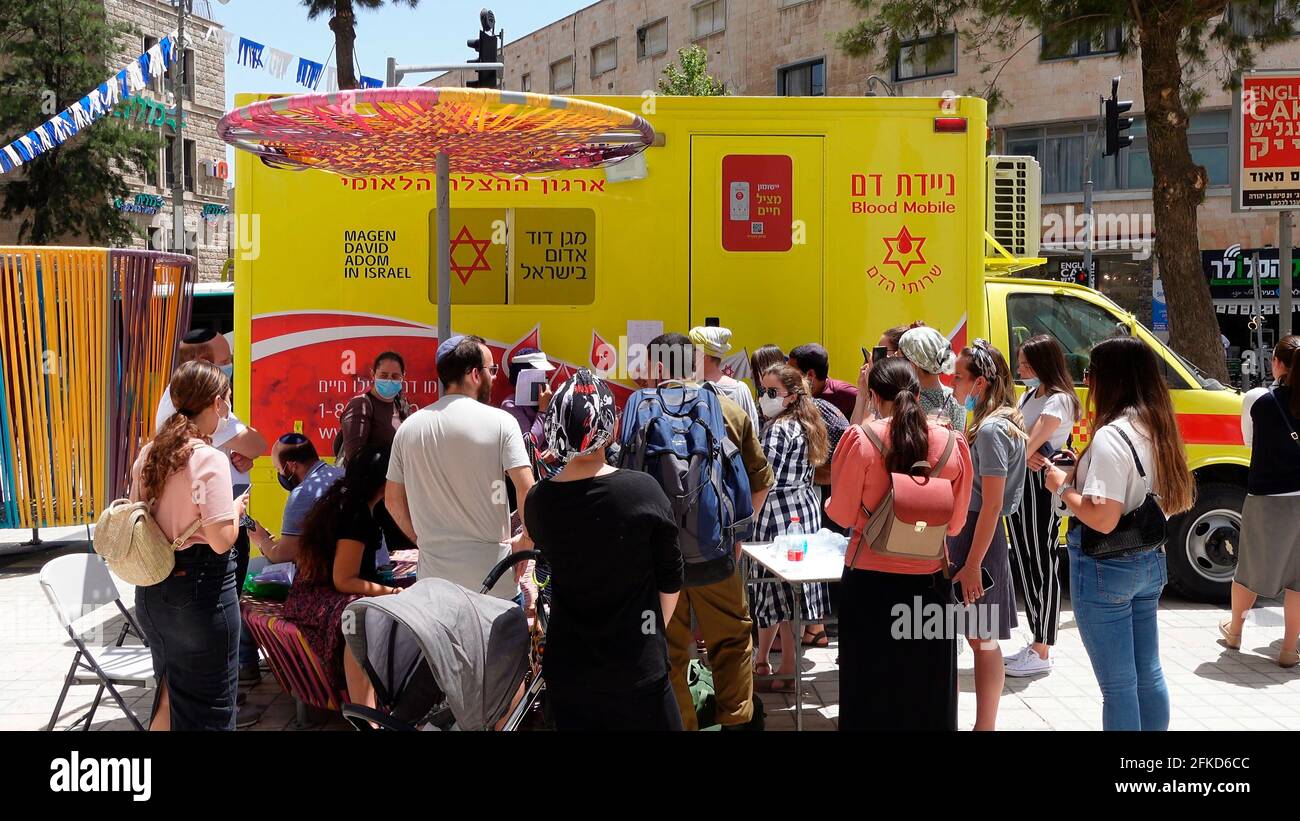 Gli israeliani si allineano per donare sangue ad un veicolo per la donazione di sangue a seguito del disastro del Monte Meron a Lag Ba'omer, che ha visto almeno 44 persone uccise il 30 aprile 2021 a Gerusalemme, Israele. 'magen David Adom' Israel emergenza medica servizio stazioni di sangue drive hanno riferito una risposta schiacciante dal pubblico, con molti mostrando alle stazioni di donare sangue. Foto Stock