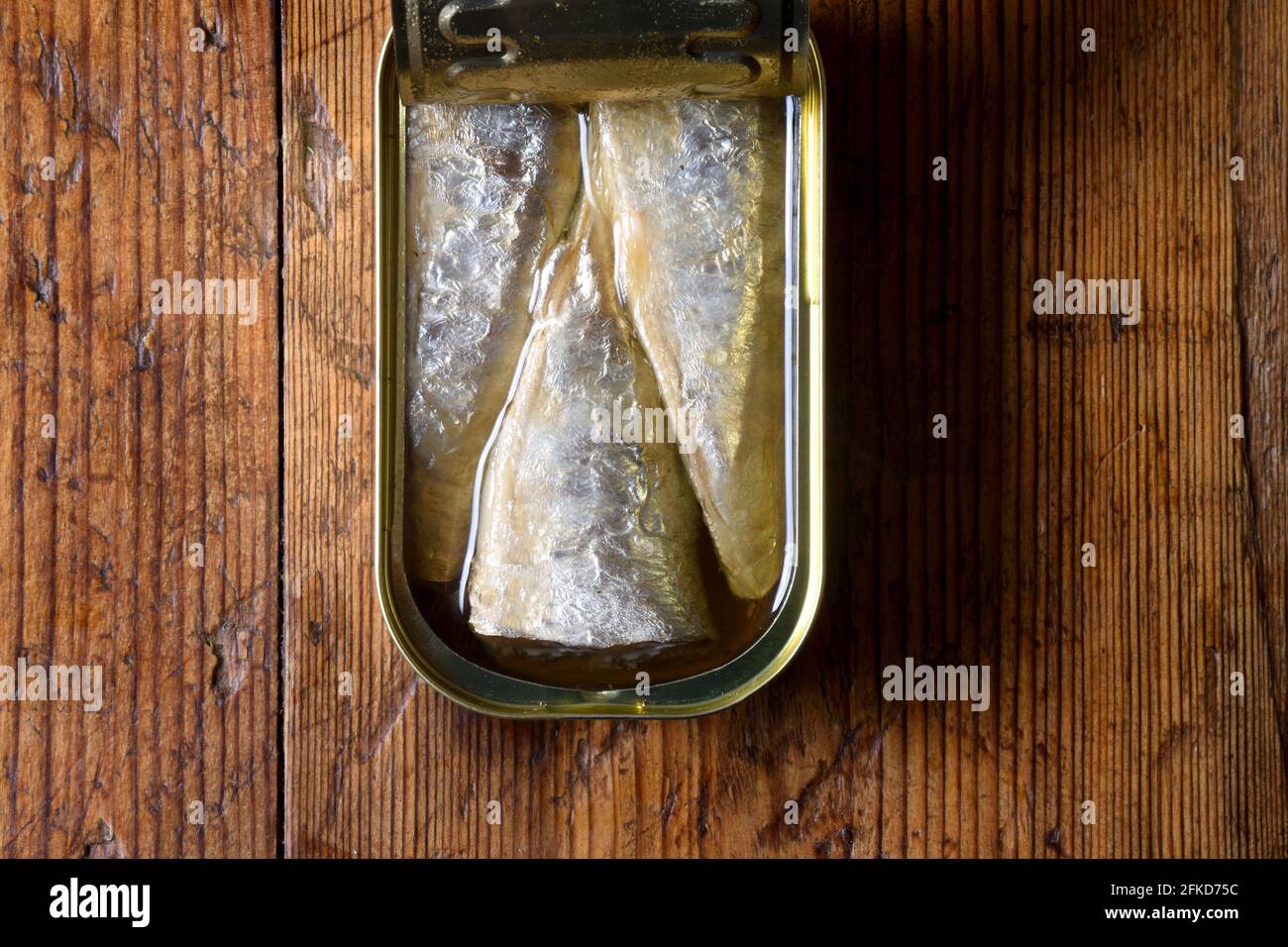 lattina di sardine su sfondo di legno Foto Stock