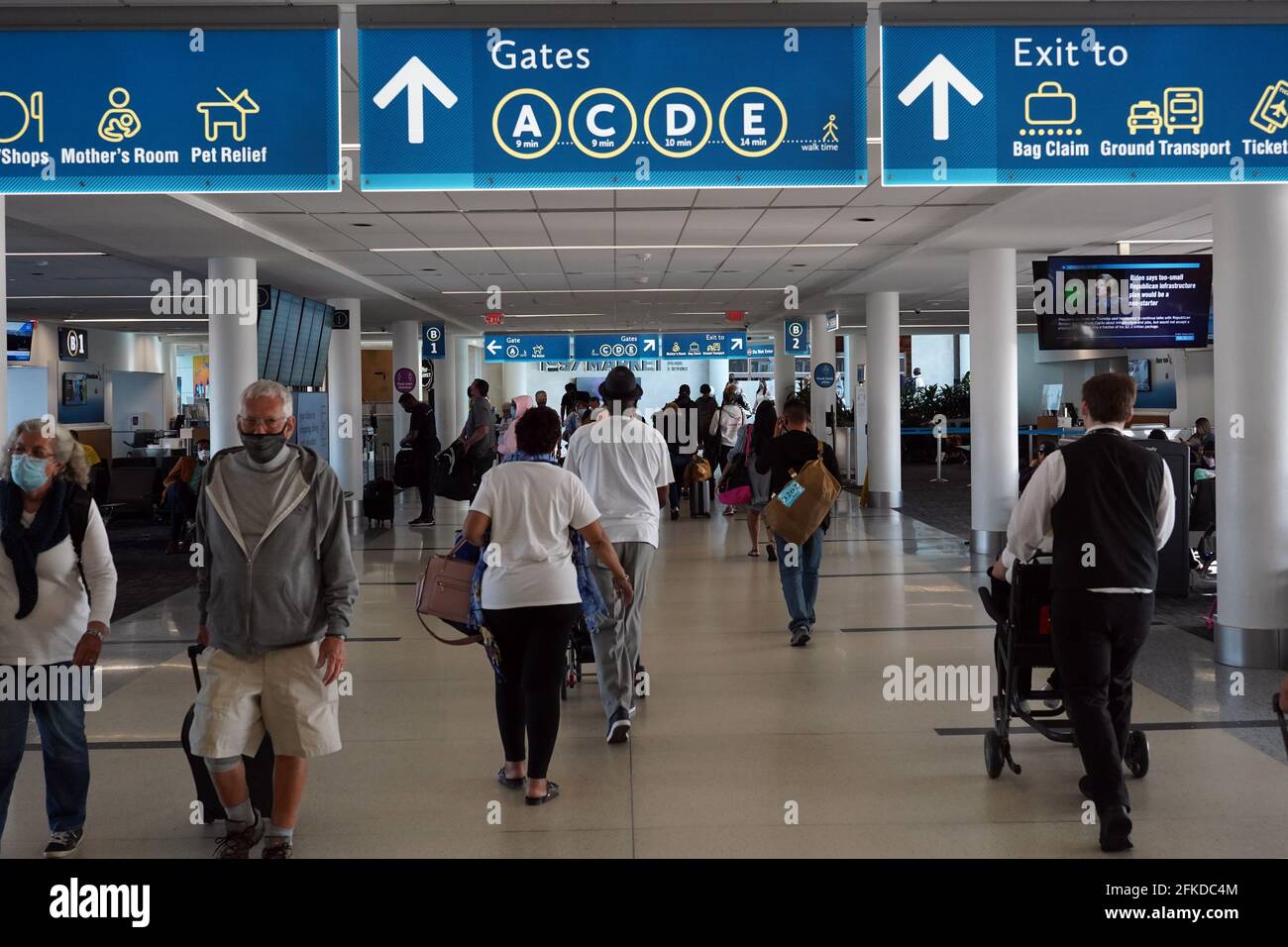 La gente cammina attraverso il terminal B Councourse all'aeroporto internazionale Charlotte Douglas, venerdì 30 aprile 2021, a Charlotte, N.B. Foto Stock