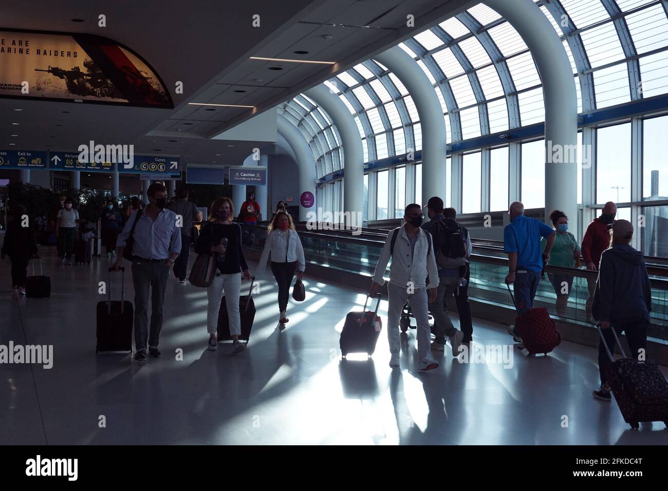 La gente cammina attraverso l'atrio centrale del terminal passeggeri all'aeroporto internazionale Charlotte Douglas, venerdì 30 aprile 2021, a Charlotte Foto Stock