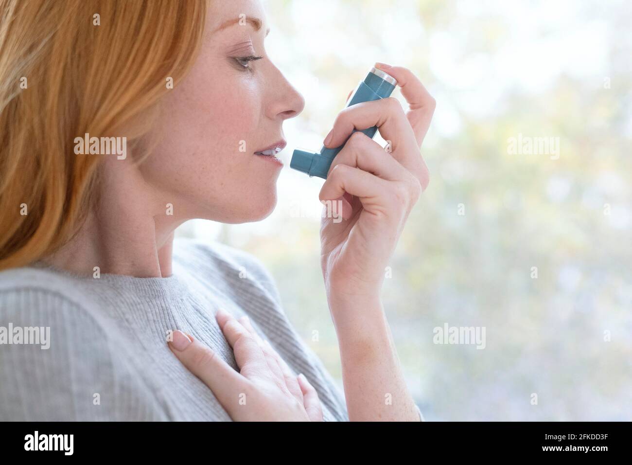 Donna che utilizza inalatore Foto Stock
