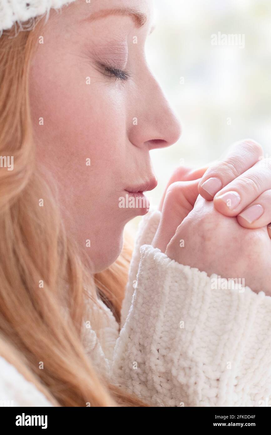 Donna riscaldando le mani Foto Stock