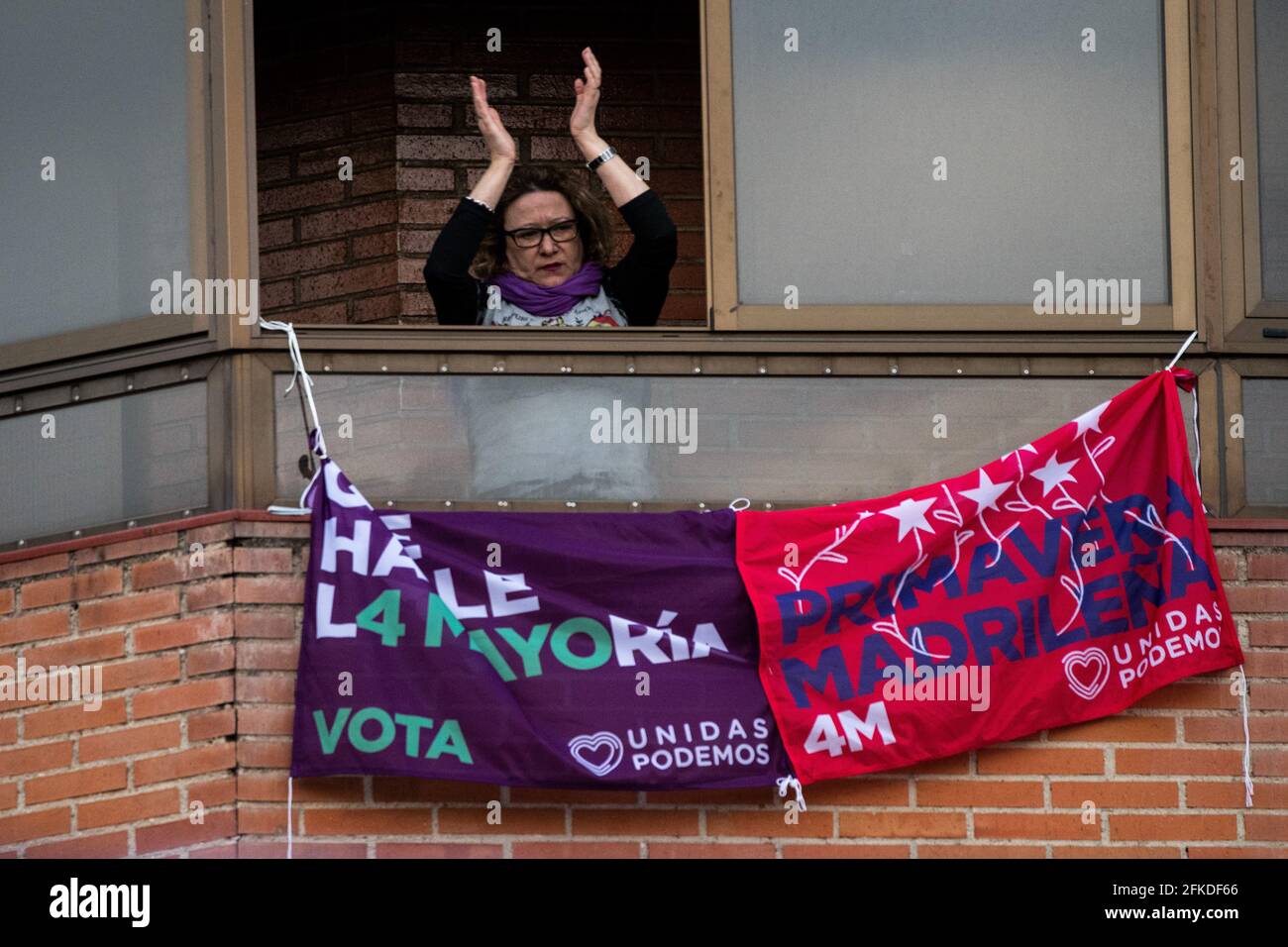 Madrid, Spagna. 30 Apr 2021. Una donna applaude da un balcone durante un raduno di Unidas Podemos festa nel quartiere di Vallecas. Unidas Podemos continua a presentare la propria candidatura per le prossime elezioni regionali di Madrid che si terranno il 4 maggio 2021. Credit: Marcos del Mazo/Alamy Live News Foto Stock