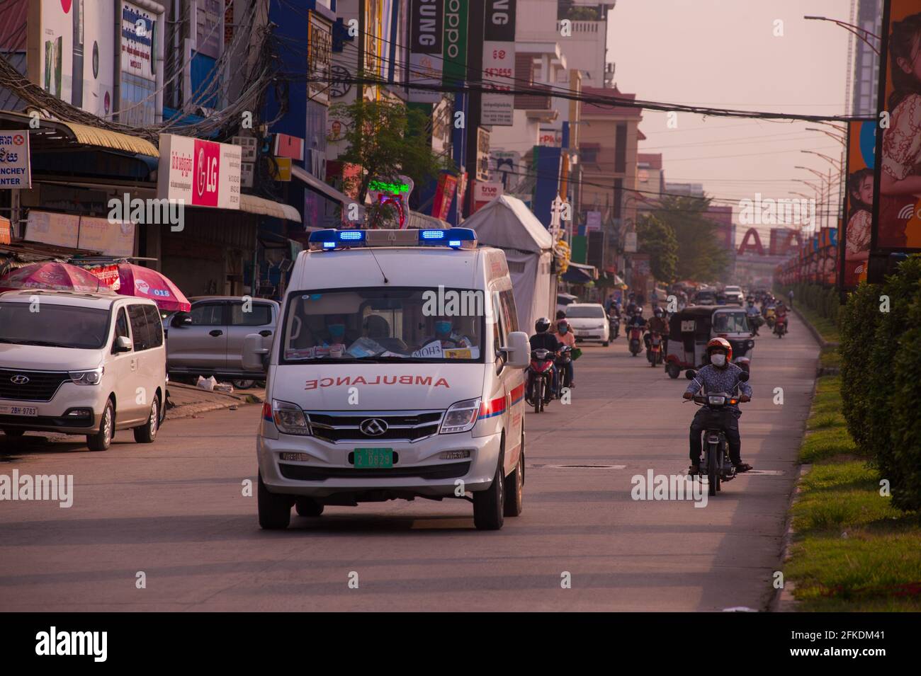 A causa di un recente focolaio di COVID - 19 in una fabbrica di indumenti, il governo cambogiano ha imposto un blocco: Qui un'ambulanza accelera la strada, in una zona rossa, portando un paziente positivo COVID all'ospedale più vicino durante la pandemia del coronavirus. Stueng Meanchey, Phnom Penh, Cambogia. 10 aprile 2021. © Kraig Lieb Foto Stock