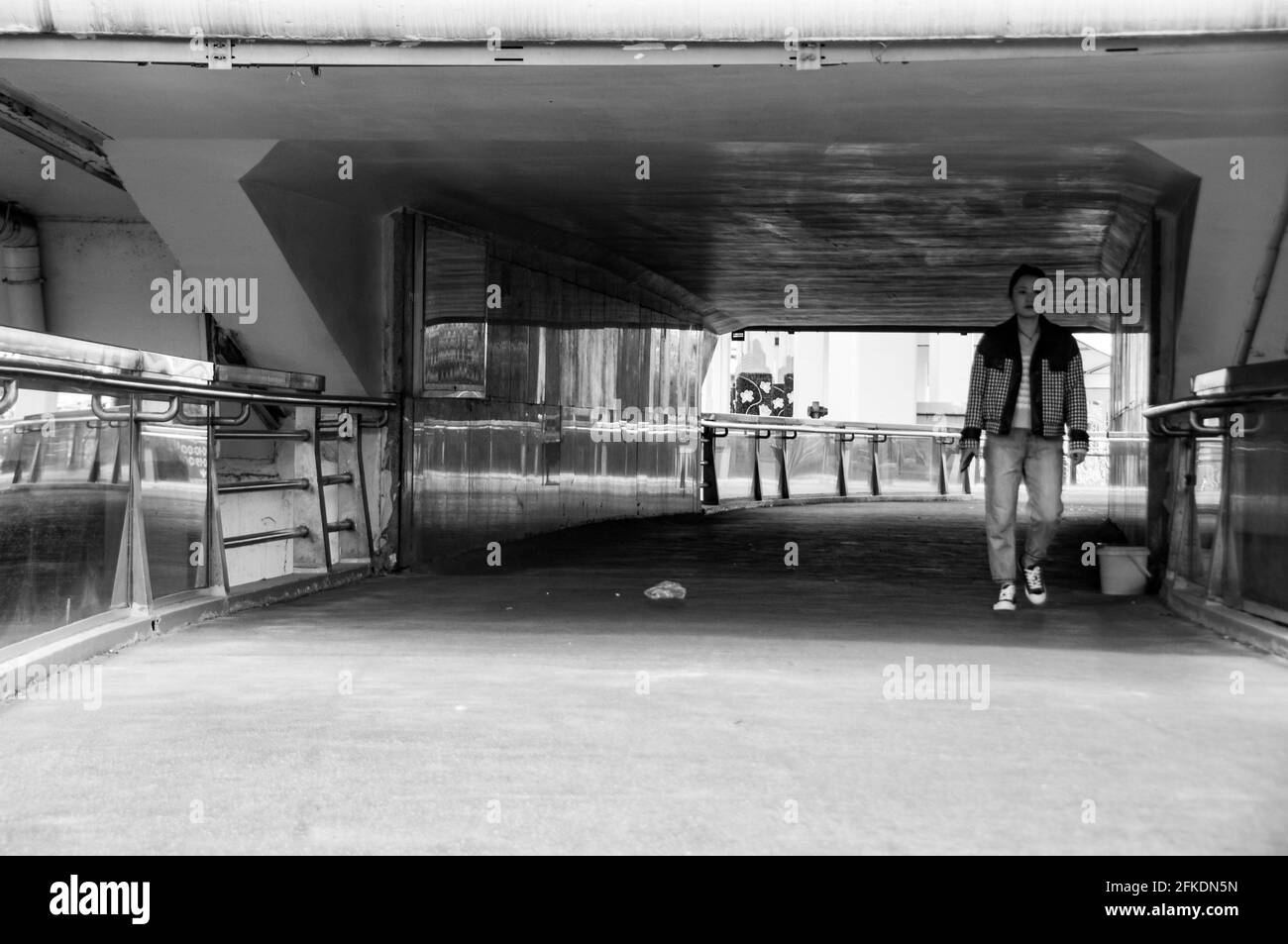 Una signora attraversa il ponte pedonale sulla Yan’an East Road e sotto la gaojia Yan’an nel centro di Shanghai, in Cina. Foto Stock