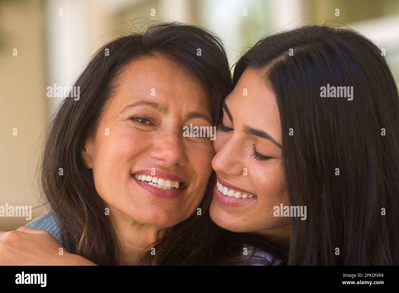Madre e sua figlia adulta che abbraccia e ride Foto Stock