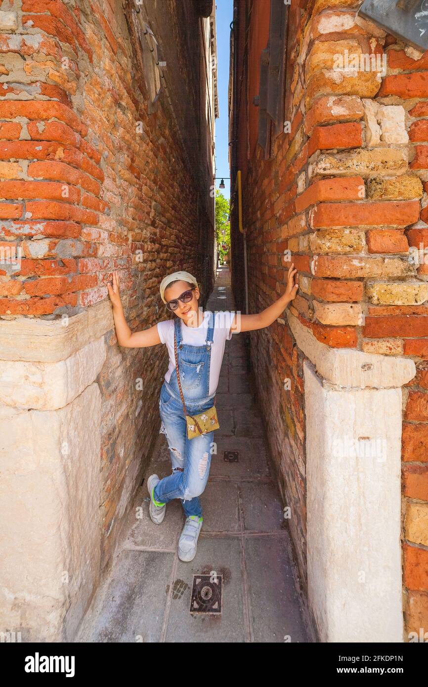 VENEZIA, ITALIA - 15 GIUGNO 2016 felice ragazza turistica mostra quanto è stretta la strada (calle Squero), sestiere Dorsoduro Foto Stock
