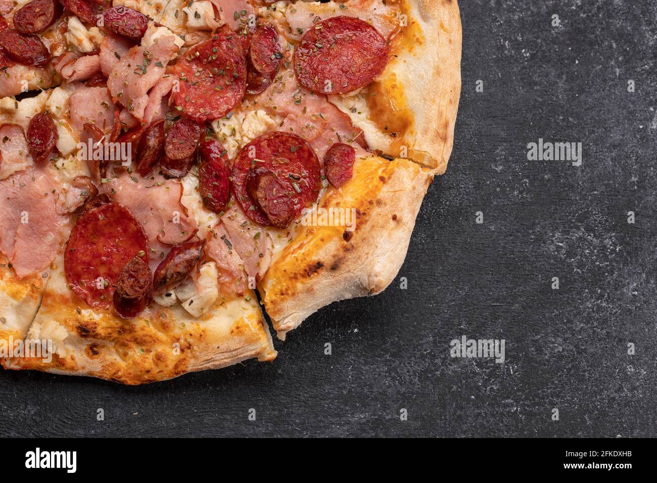 Quattro pizza di carne su fondo di cemento scuro Foto Stock