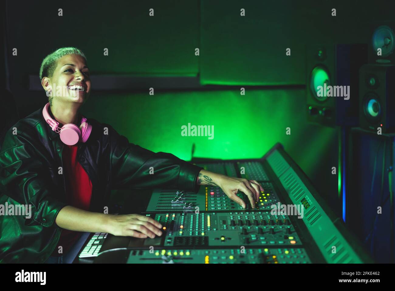 Giovane donna che lavora in studio di registrazione musicale - Audio femminile ingegnere che mescola un suono in casa di produzione Foto Stock