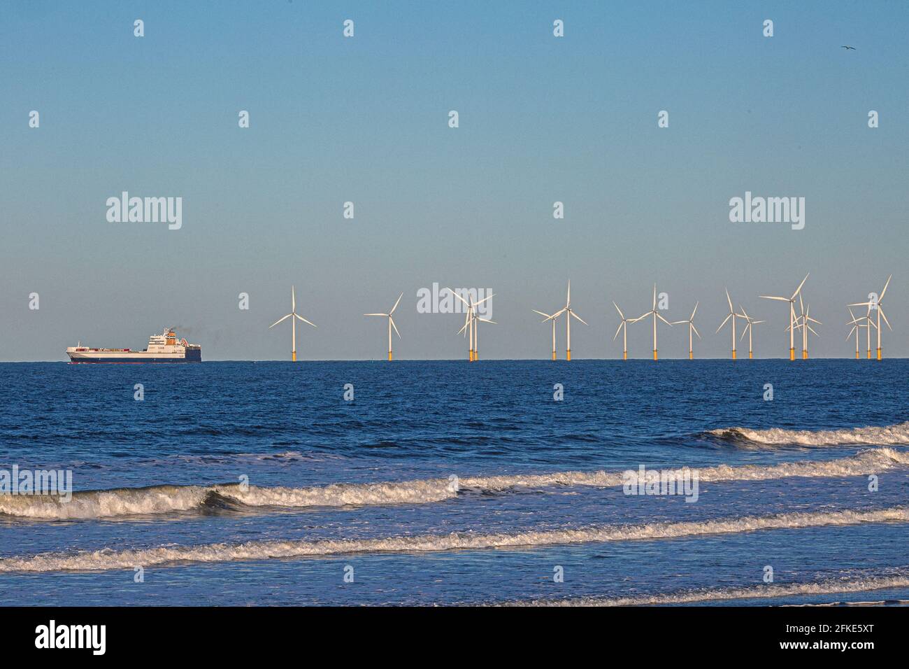 Nave del contenitore che passa il Windfarm offshore Teesside . Inghilterra, Regno Unito Foto Stock