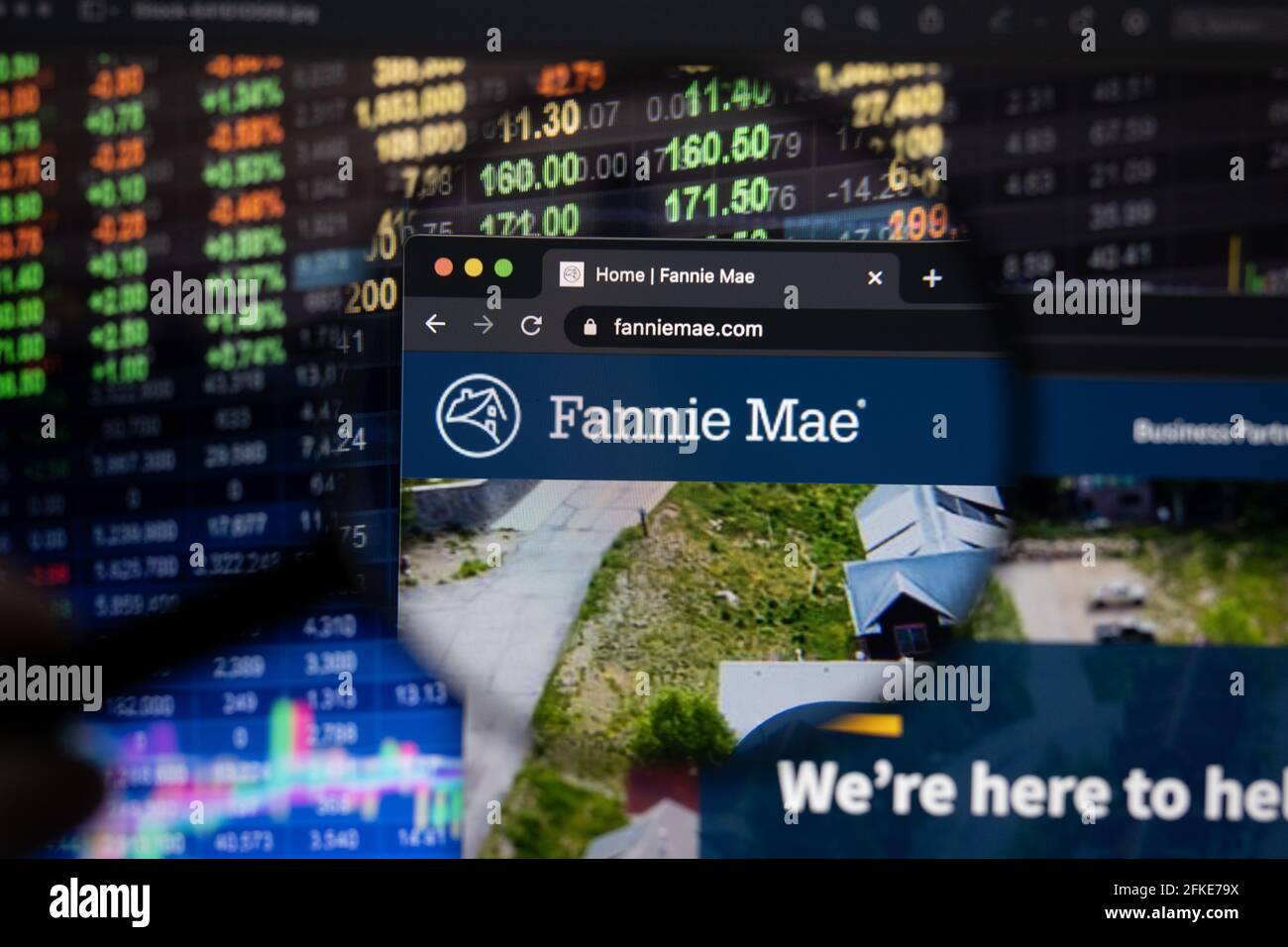 Logo di Fannie Mae Company su un sito web con sviluppi del mercato azionario sfocato in background, visto su uno schermo del computer attraverso una lente di ingrandimento Foto Stock