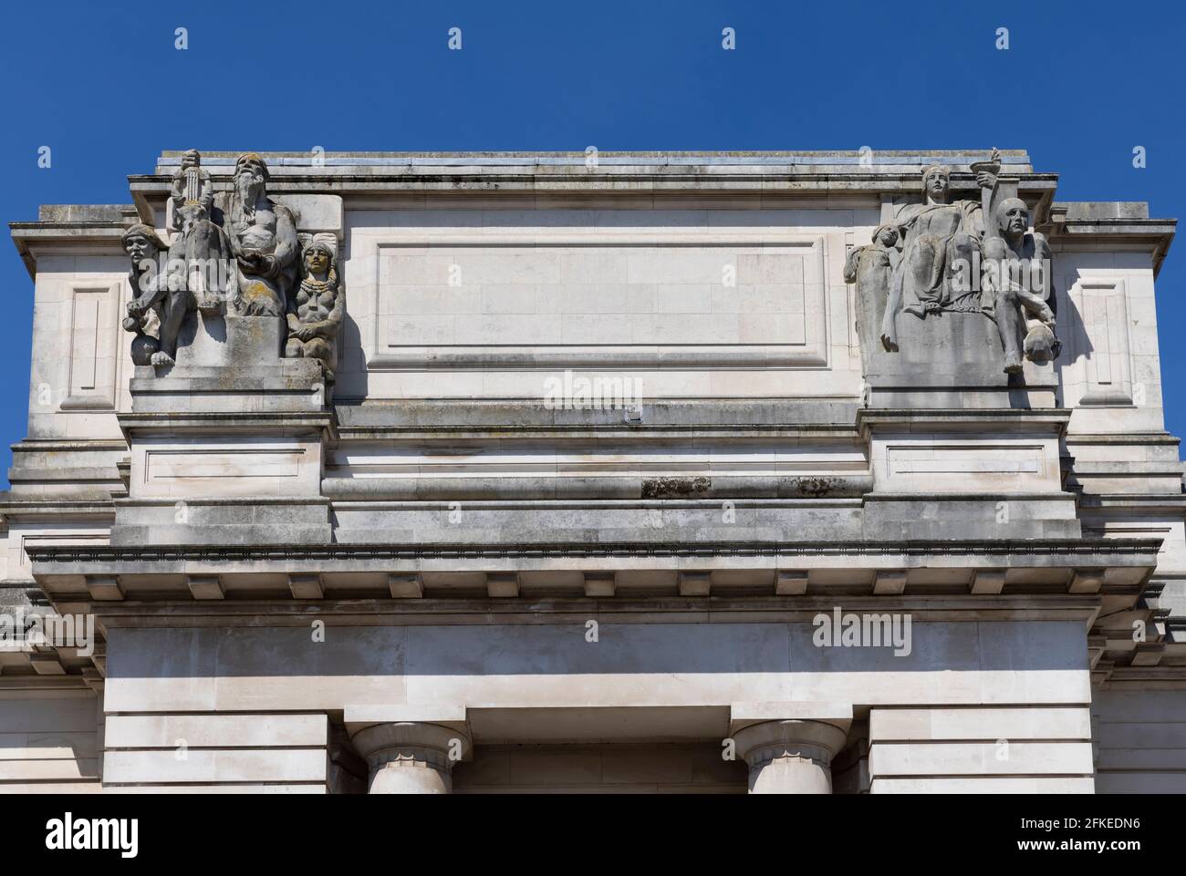 Sculture architettoniche sul Museo Nazionale di Cardiff raffiguranti il periodo preistorico (a sinistra) e il periodo classico (a destra). Cardiff, galles, Regno Unito Foto Stock