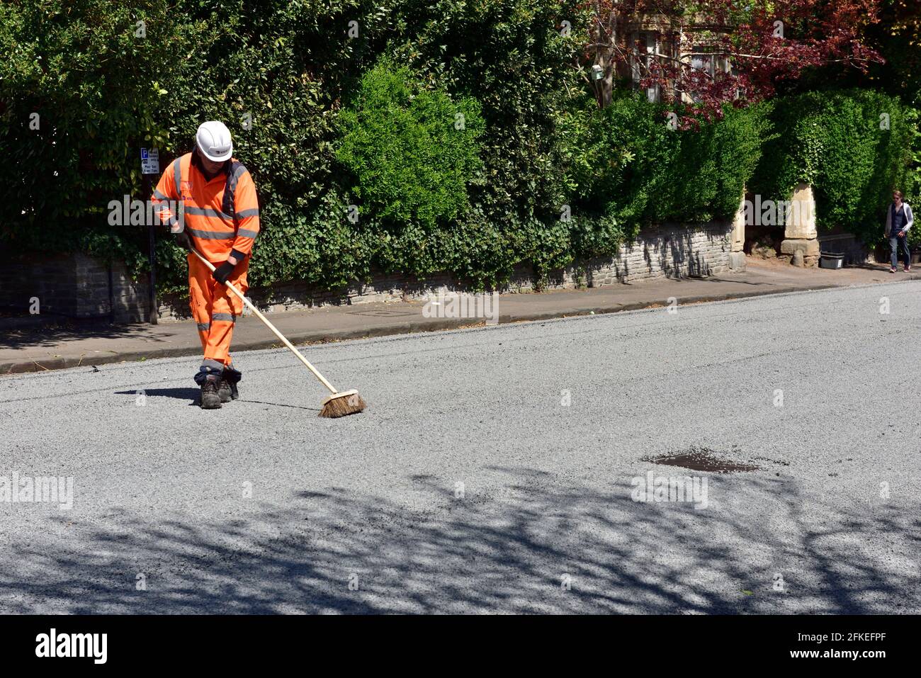 Manutenzione stradale spazzare su perdere scheggiature dopo lo spargimento di bitume e. trucioli di ghiaia per la rettifica stradale Foto Stock