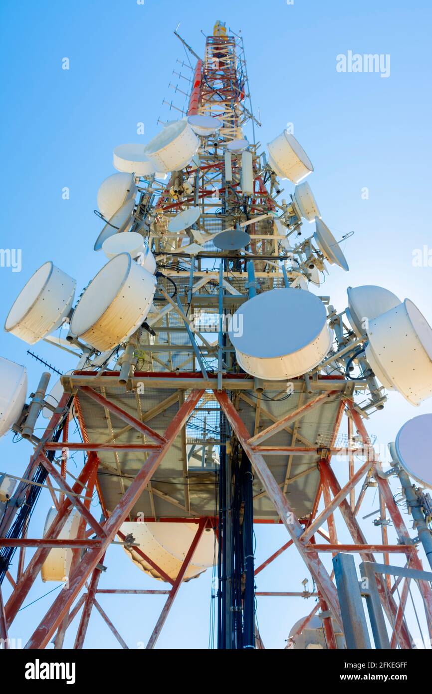 Vista ad angolo basso di una torre di comunicazione con antenne paraboliche Foto Stock