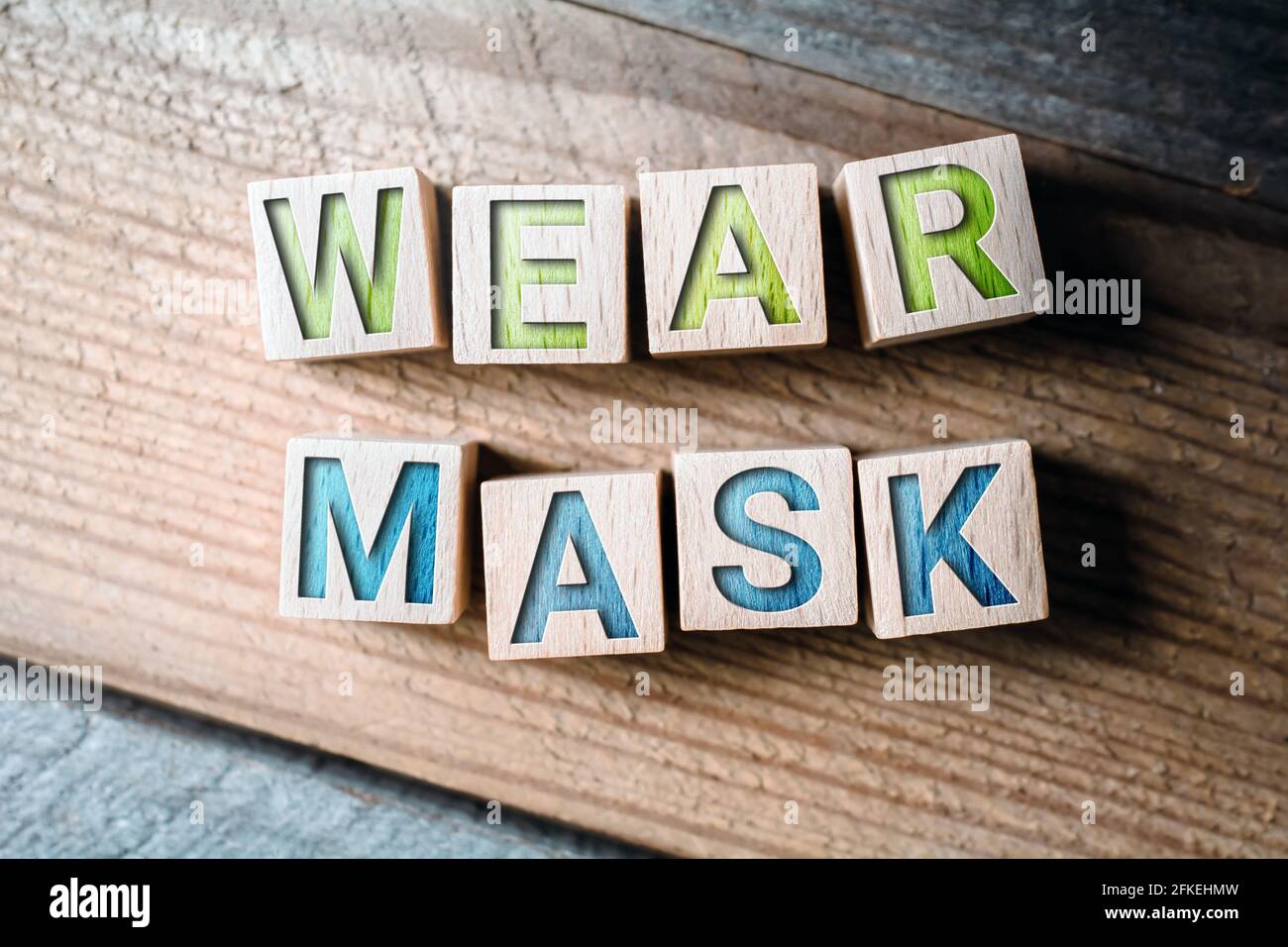 Maschera di usura scritta su blocchi di legno su una tavola Foto Stock