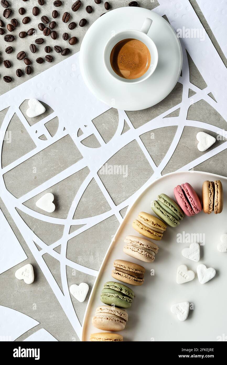 Tazza da caffè, macaron, cerchi di sequenza Fibonacci, cuori di zucchero. Perfezione gustosa. Espresso e chicchi di caffè torrefatti scuri. Rapporto d'oro. Vista dall'alto Foto Stock