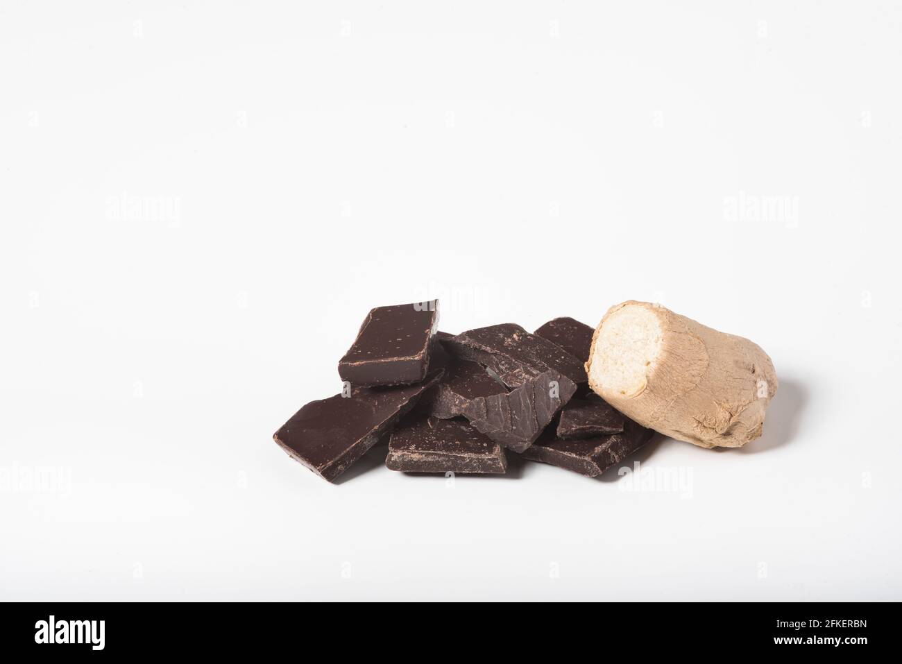 Primo piano di pezzi di cioccolato e una sezione di radice di zenzero. Foto Stock