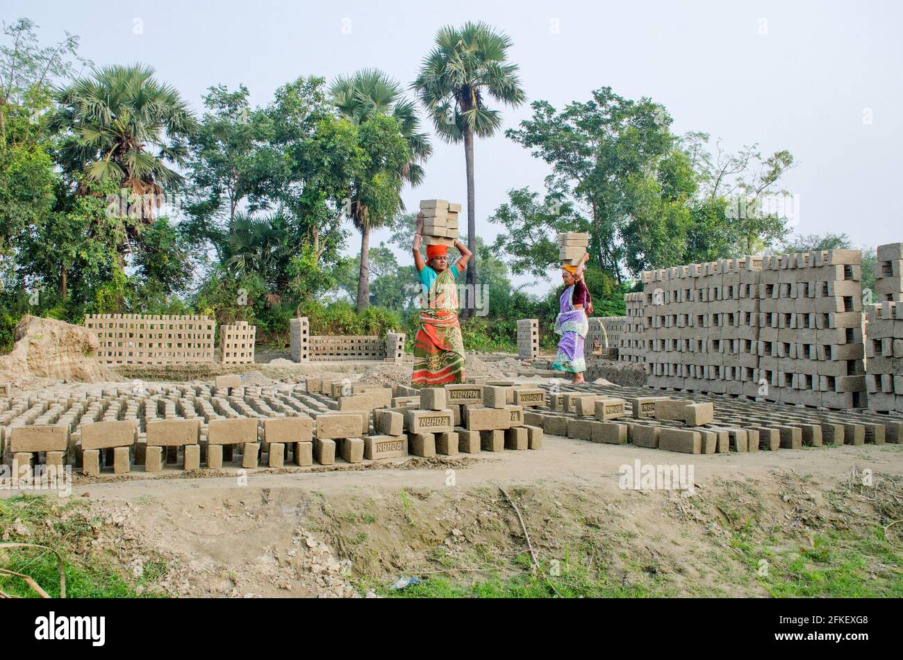 Immagine di un forno di mattoni nel remoto distretto di Hooghly. Lavoratori adulti lavorano duro per disporre i mattoni crudi nel forno a cotti. Foto Stock