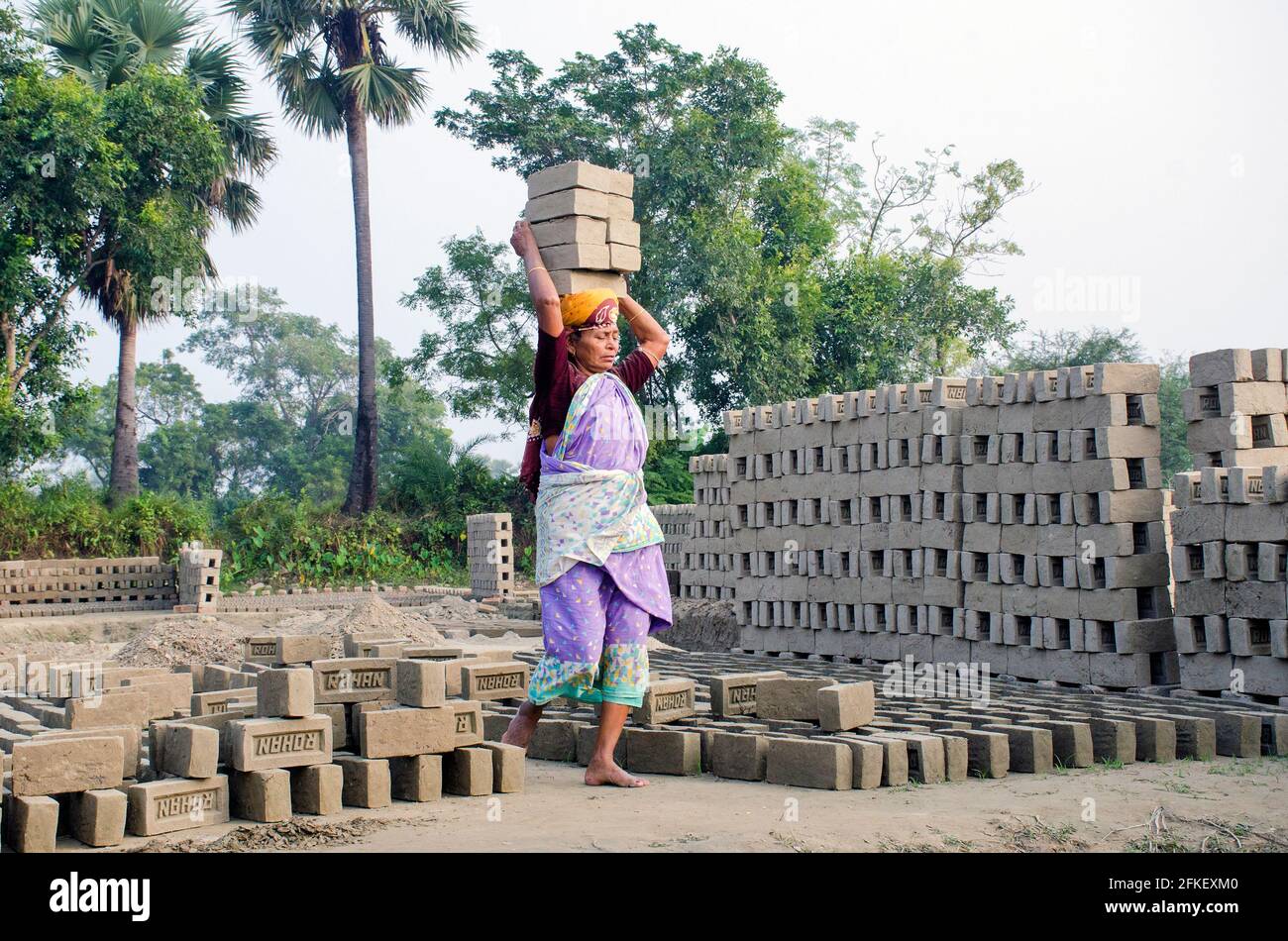 Immagine di un forno di mattoni nel remoto distretto di Hooghly. Lavoratori adulti lavorano duro per disporre i mattoni crudi nel forno a cotti. Foto Stock
