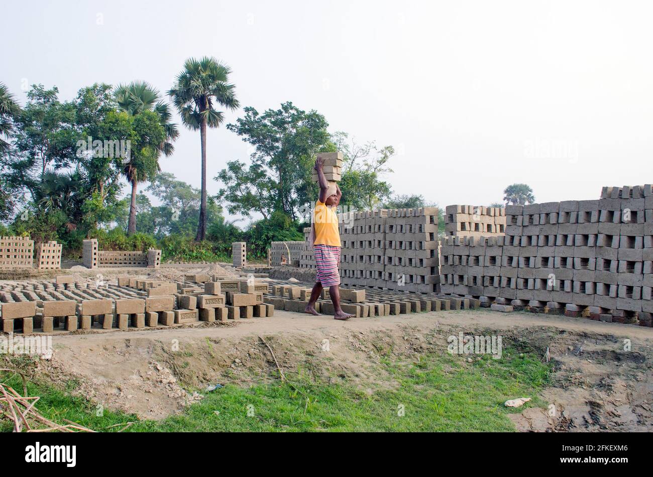 Immagine di un forno di mattoni nel remoto distretto di Hooghly. Lavoratori adulti lavorano duro per disporre i mattoni crudi nel forno a cotti. Foto Stock
