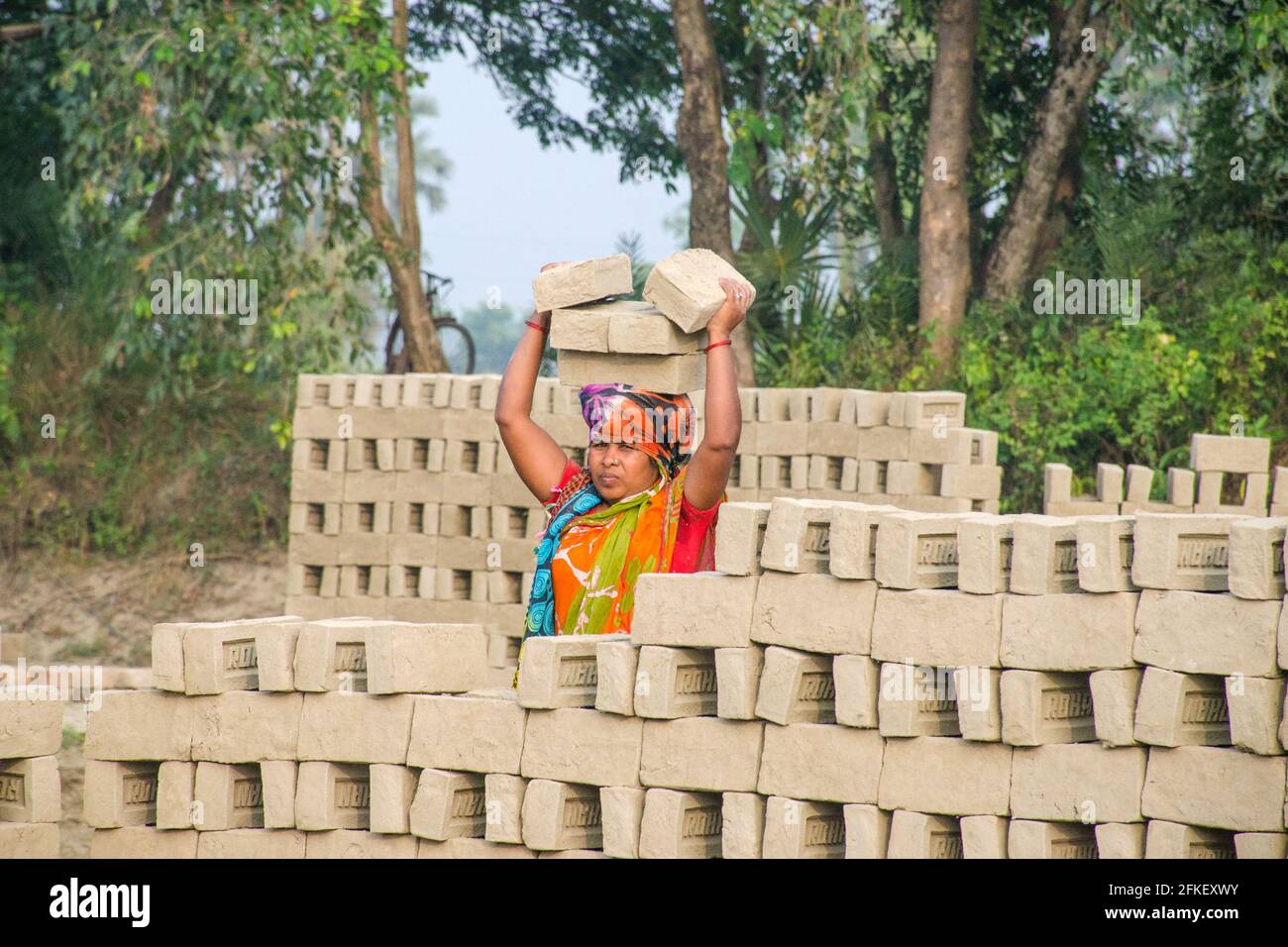 Immagine di un forno di mattoni nel remoto distretto di Hooghly. Lavoratori adulti lavorano duro per disporre i mattoni crudi nel forno a cotti. Foto Stock