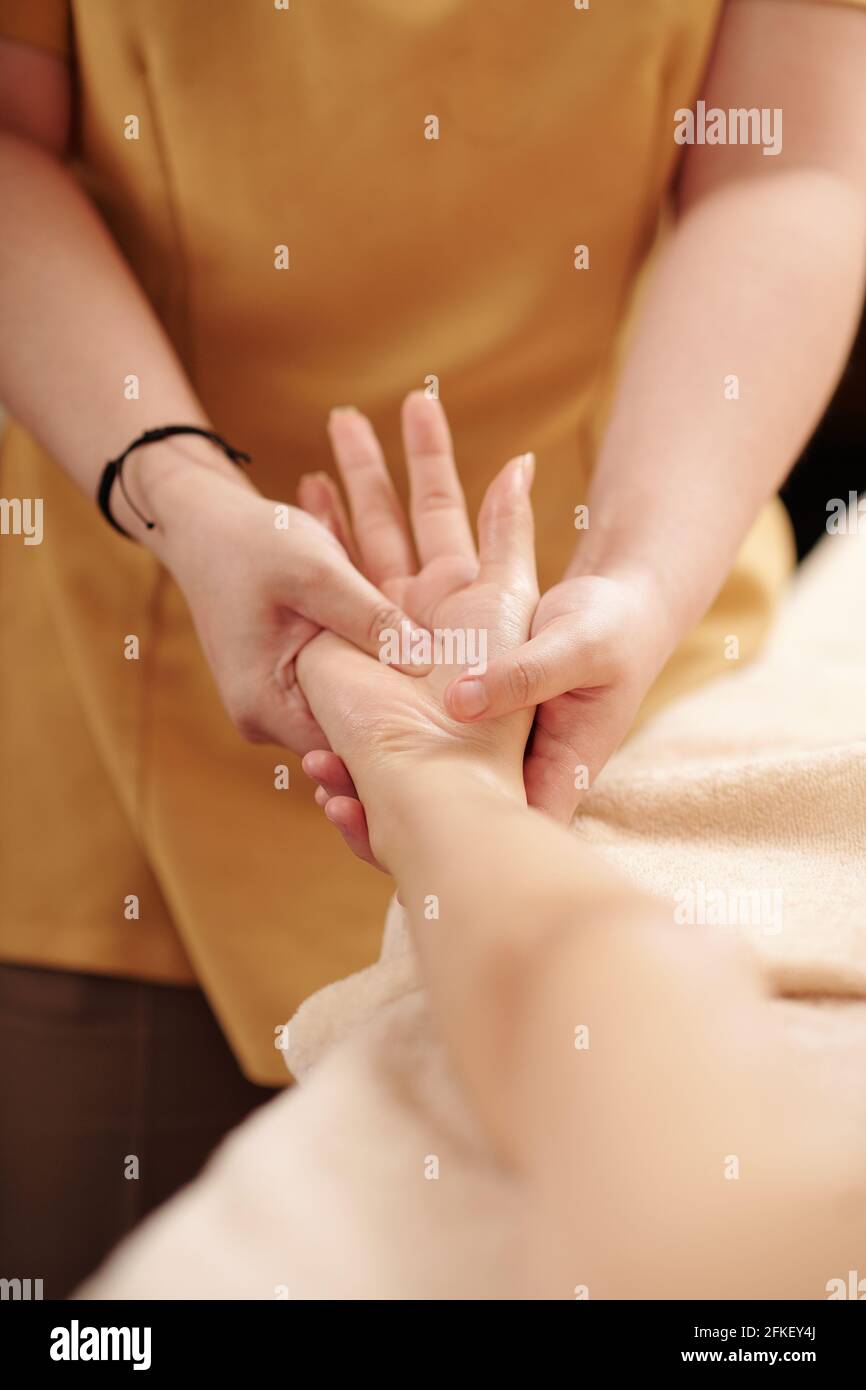 Immagine ravvicinata di estetista massaggiante mani di cliente femminile a. ripristinare l'equilibrio nel corpo e diminuire l'ansia Foto Stock